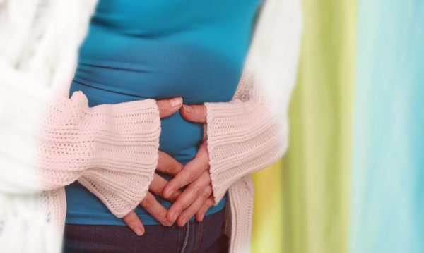 Frau hält sich den Bauch